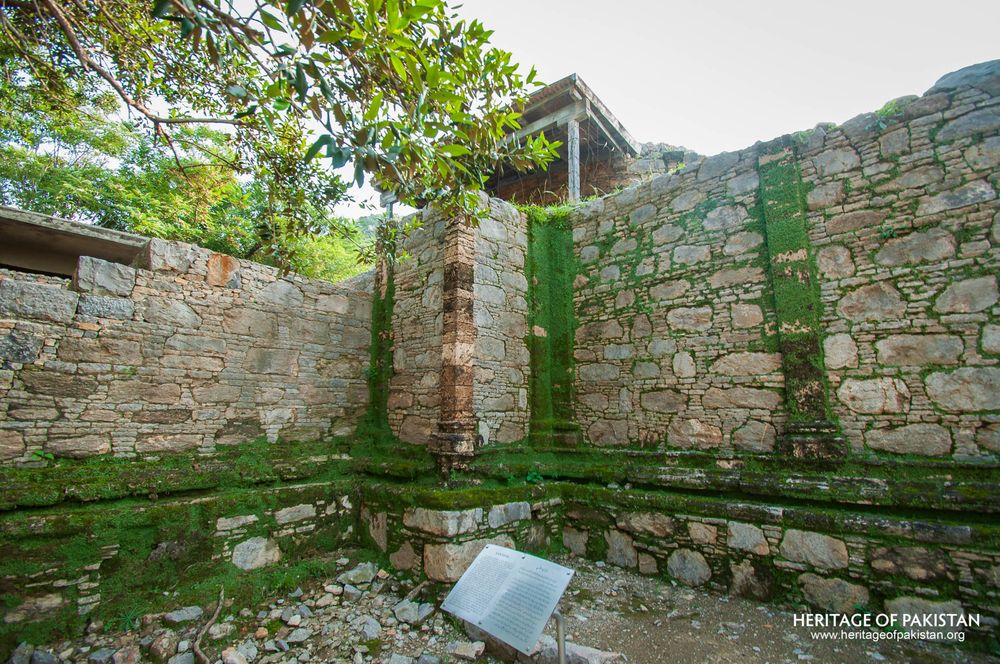 Stone courtyard with reflective water at Mohra Moradu